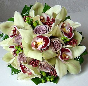 Wedding gift flowers arrangement made of  cymbidium orchids, roses, skimya japonica, hypericum